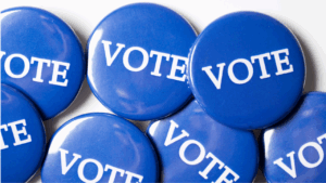 Pinback buttons that have the word VOTE printed on them.