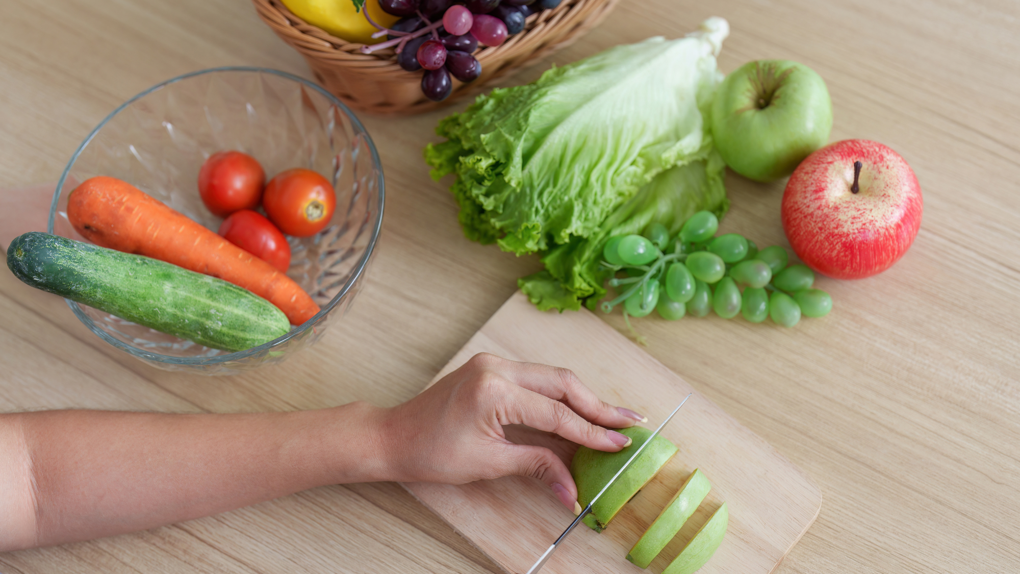 Person preparing fresh fruits and vegetables.