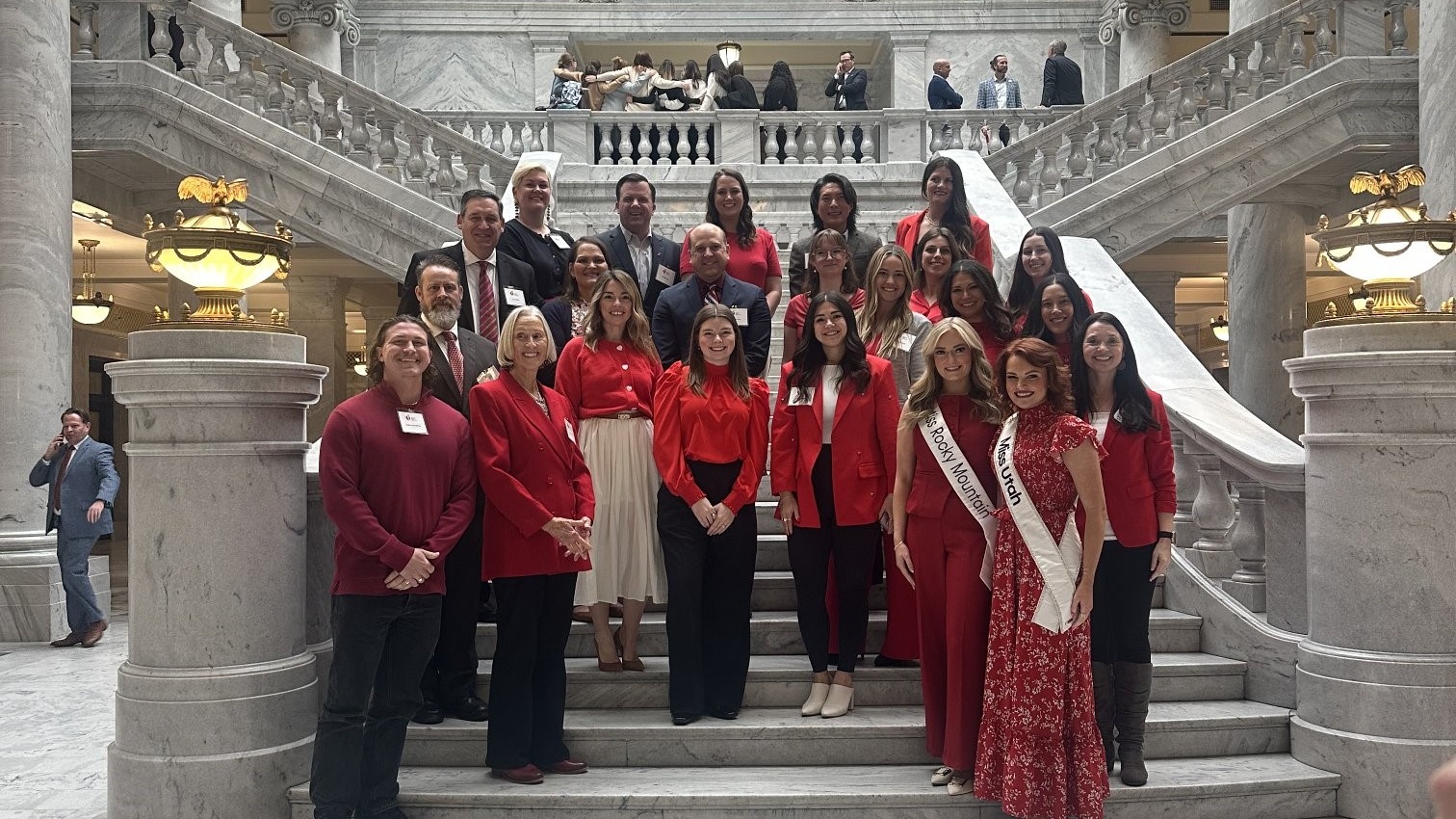 A group of 20 people standing on the marble steps inside the Utah Capitol building.