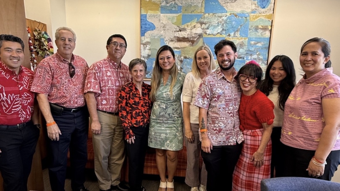 A group of people standing side by side in an office.