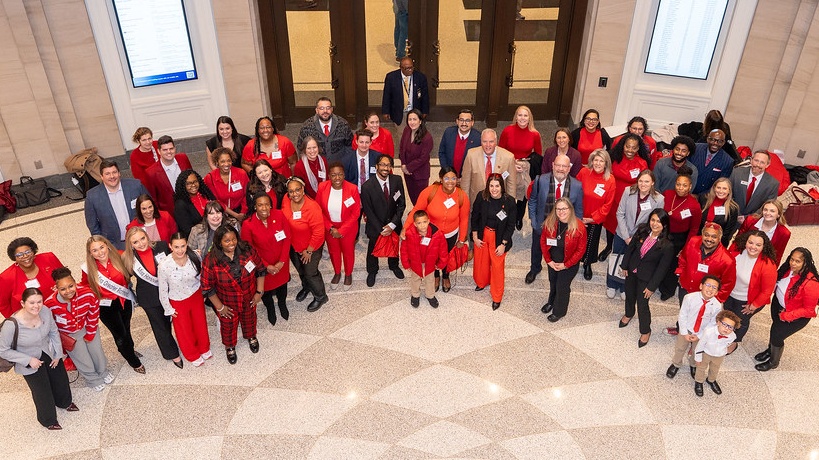 A group of people in red, looking at the camera and smiling